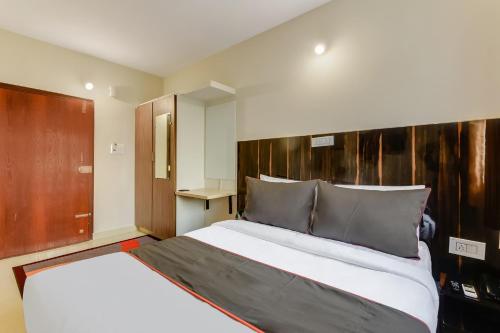 a bedroom with a large bed and a wooden headboard at Hotel O Vittala Comforts in Bengaluru