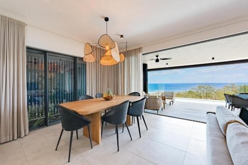 a dining room with a table and chairs at Legend Hill Resort and Spa in Rivière Noire