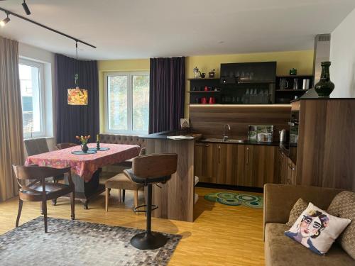 a kitchen and living room with a table and chairs at Apartments im LOIDLs GUESTHOUSE in Traunkirchen