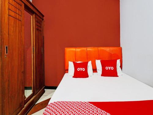 a bedroom with a bed with two red pillows at OYO Life 92127 Skyland Pasteur in Bandung