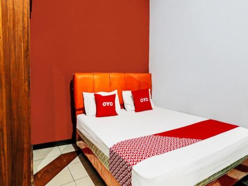 a bedroom with a bed with two red pillows at OYO Life 92127 Skyland Pasteur in Bandung