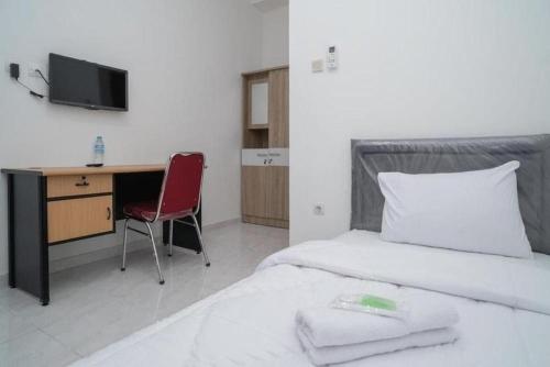 En eller flere senge i et værelse på Hotel O Mahagoni House Syariah