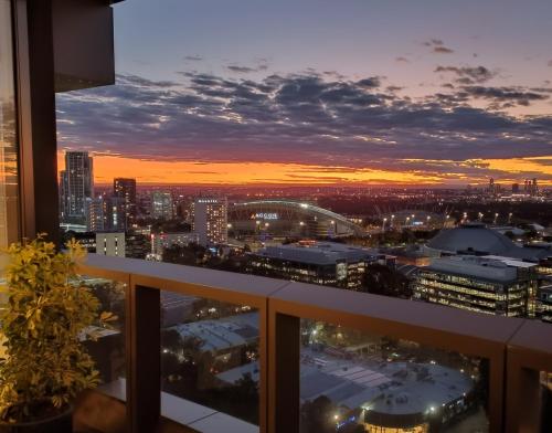 a view of a city at sunset from a balcony at 'The Australia St-ar' 2x King beds in Sydney