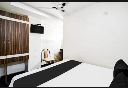 a bedroom with a bed and a chair at Hotel Sun Residency in Hyderabad