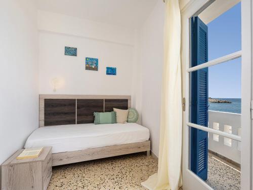 a bedroom with a bed and a view of the ocean at Lefka Ori in Khóra Sfakíon