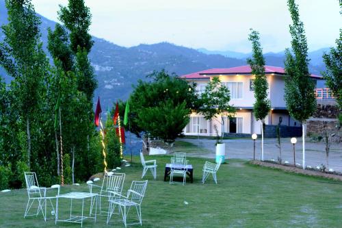a group of chairs and tables in a yard at Ihram Hotel And Guest House in Swat