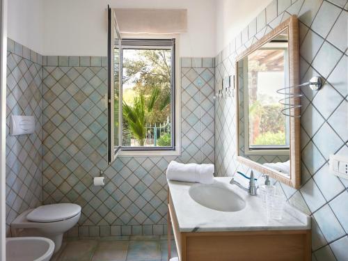 カーラ・リベロットにあるOrosei Home Holidays - Sa Vaddeのバスルーム(洗面台、トイレ付)、窓が備わります。