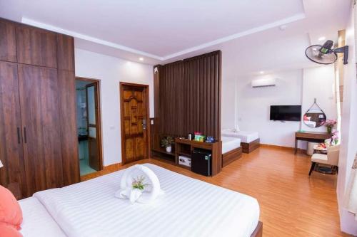 a bedroom with a large white bed and a bathroom at Yen Nhi Hotel Ninh Binh in Ninh Binh