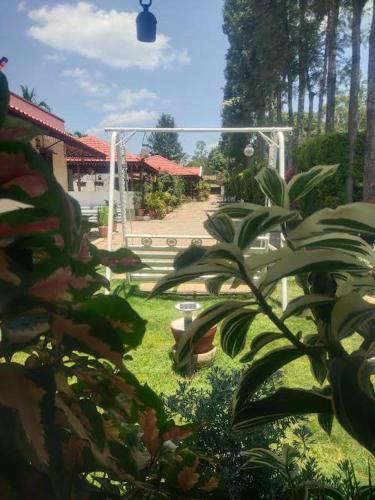 a view of a garden with a building and a park at Tigerwoods Cottage in Chikmagalūr