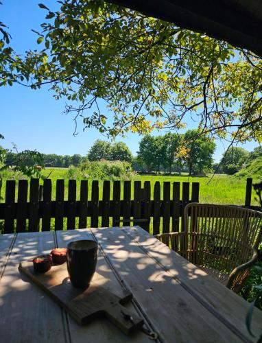 a wooden table with a cup on top of it at Natuurhuisje Hoogeloon PMV in Hoogeloon