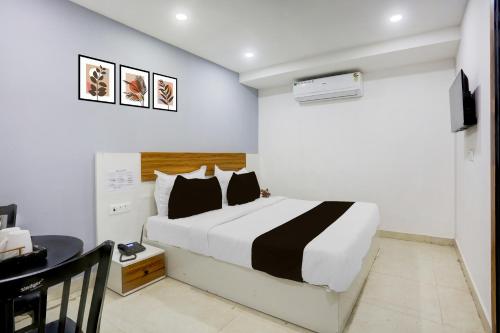 Un dormitorio con una cama blanca y negra y un escritorio. en Hotel O Silver Stone, en Nueva Delhi