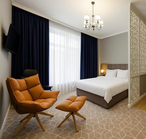 a hotel room with a bed and a chair at Tauke Khan Plaza in Shymkent