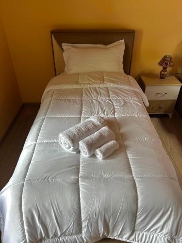 a white bed with two towels on it at Vila Bashllari in Zvarisht