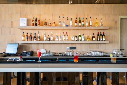 a bar with a bunch of bottles on the wall at AR Suites KLJ Square in Gurgaon