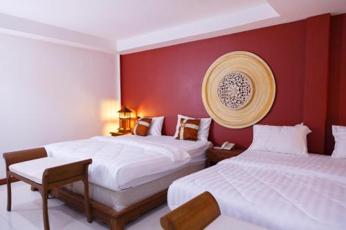 two beds in a room with red walls at Elite Home stays by UPAR, Silom in Bangkok