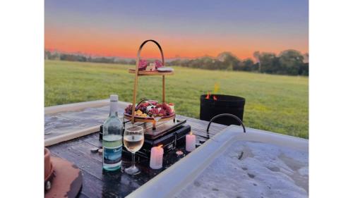 a picnic table with a bottle of wine and glasses at Echidna by Tiny Away in Thoopara