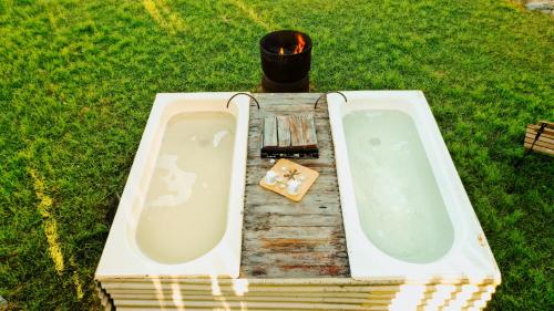 a bath tub sitting on top of a field of grass at Echidna by Tiny Away in Thoopara