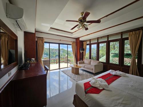 a bedroom with a bed and a ceiling fan at Phangan Utopia Resort in Mae Haad