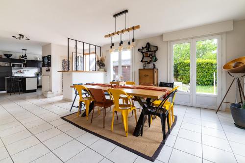 une cuisine et une salle à manger avec une table et des chaises dans l'établissement Maison familiale - Spacieuse - Wifi - Parking, à Sainte-Anne-d'Auray