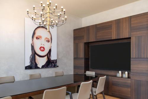 a dining room with a large painting of a woman at ME Milan Il Duca in Milan