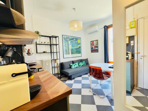 une cuisine et un salon avec un canapé et une table dans l'établissement New Alba 3 Pers WiFi AC, à Nice