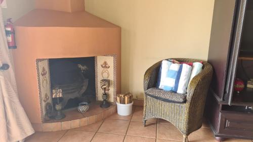 a living room with a chair and a fireplace at Robin Cottage Da Gama Lake in White River