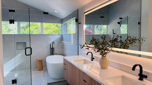 a bathroom with two sinks and a glass shower at Brand New Architectural Gem 1900 sqft House with SPA bathroom 15min to downtown in Seattle