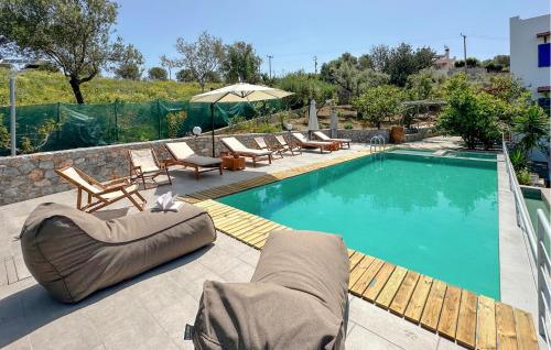 a swimming pool with chairs and a couch next to it at Gorgeous Home In Platanias,Rethymno in Platanes