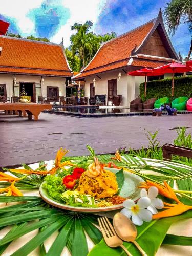 a plate of food on a table in front of a building at Baan Thai Lanta Resort in Ko Lanta