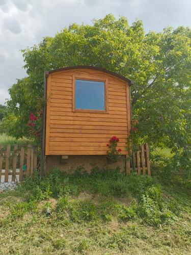 a small wooden house with a window on a fence at La casetta sotto l'albero LA CAROVANA GITANA in Vasto