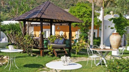 a gazebo with tables and chairs in a yard at Hotel Oasi in Panarea