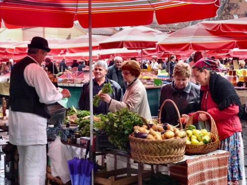 un grupo de personas alrededor de un mercado con frutas y hortalizas en Apartment Grado, en Zagreb