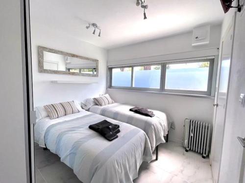 two beds in a room with two windows at housingcoruña BASTIAGUEIRO in Bastiagueiro