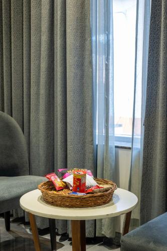 a basket of snacks on a table next to a window at Coral Reef Hotel & Spa, Port Blair in Port Blair