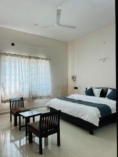 a bedroom with a bed and a table and chairs at Nalini s comfort inn in Haldwāni