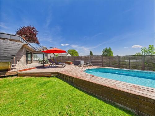 a backyard with a swimming pool and a wooden deck at Step by Stef in Bertrix