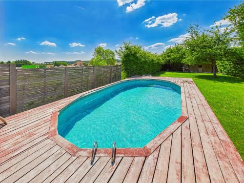 a swimming pool on a wooden deck with a fence at Step by Stef in Bertrix