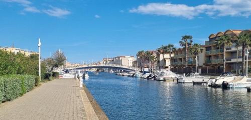 une rivière avec des bateaux, des bâtiments et un pont dans l'établissement Apartment in Port Gruissan, à Gruissan