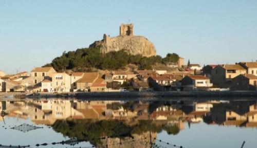 une ville avec un château au sommet d'une colline dans l'établissement Apartment in Port Gruissan, à Gruissan