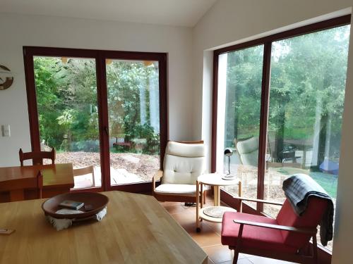 a living room with a table and chairs and large windows at Ahlberg Ferienhaus in Mariendorf