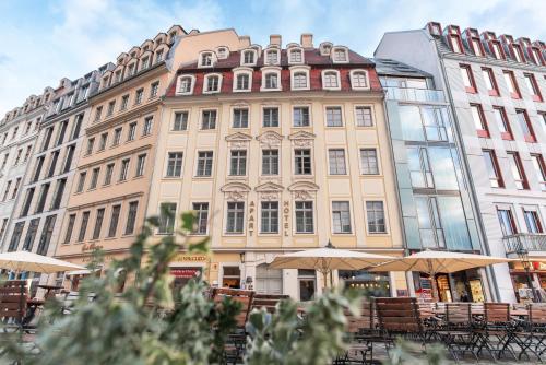 a large building with tables and umbrellas in front of it at Maisonette-Apartment An der Frauenkirche in Dresden