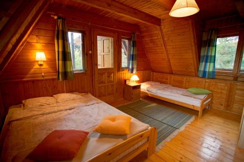 a bedroom with two beds in a wooden cabin at Dom z Bali Paweł nad jeziorem Tajty in Giżycko