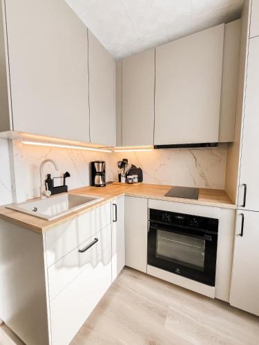 a kitchen with white cabinets and a sink at Lahemaa Seaside Studio in Loksa