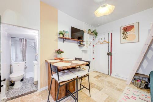 Cette petite chambre comprend une table et des toilettes. dans l'établissement Petit studio cosy quartier branché entre Bastille et Nation, à Paris