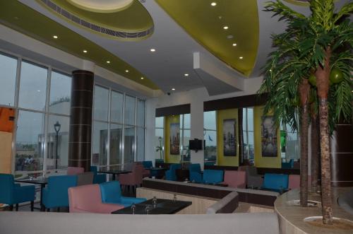 a lobby with a waiting area with blue and pink chairs at Maha Bodhi Hotel.Resort.Convention Centre in Bodh Gaya