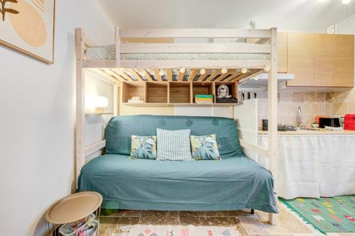 - une chambre avec des lits superposés et un canapé bleu dans l'établissement Petit studio cosy quartier branché entre Bastille et Nation, à Paris