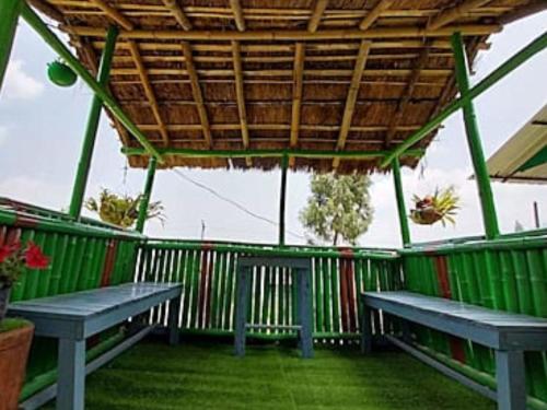 two benches in a building with a wooden roof at The Wooden Homestay By StayApart in Rishop
