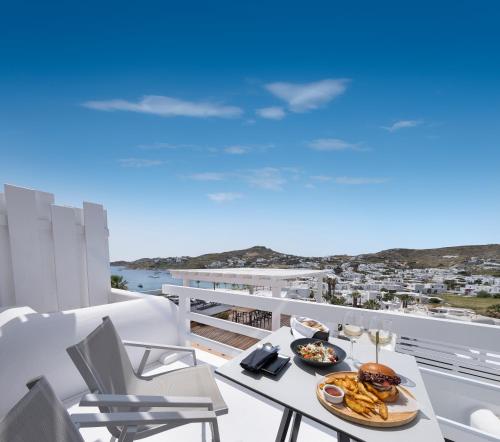 a table with a plate of food on a balcony at Deliades Hotel in Ornos