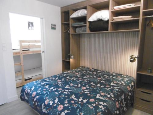 a bedroom with a bed with a floral bedspread at Appartement YOUN - à 500 m de la plage WIFI in Sarzeau