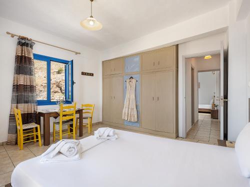 a bedroom with a bed and a table and chairs at Lefka Ori in Khóra Sfakíon